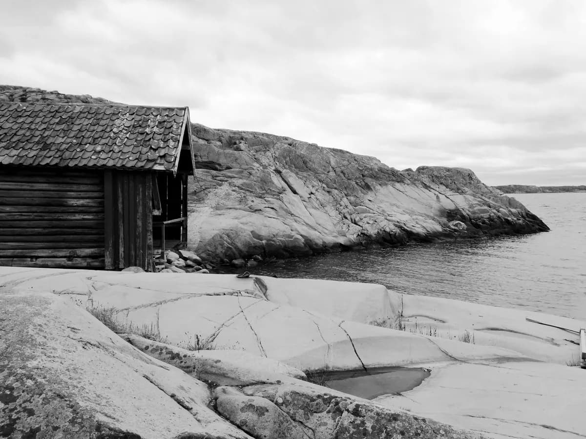 Timmerhus på klipphäll vid vattnet